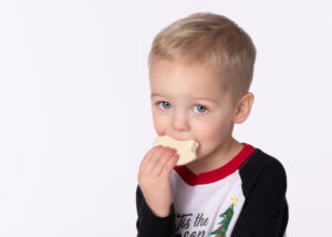 Close up of a cute toddler boy eating a cookie