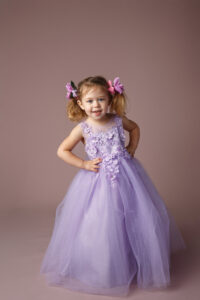 Cute two toddler girl wearing a purple dress and pig tails