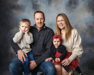 Professional Portrait of a Family of four with dad, Mom small boy and girl taken on a studio background