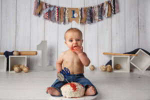 Photo of one year old baby in Baseball themed first birthday cake smash 