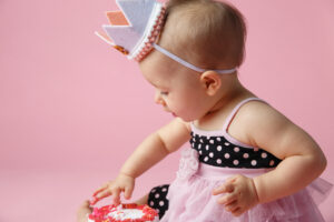 Little one year old girl' photographed on pink background by Janesville, Wisconsin photo studio,