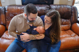 Mom and dad on the couch with their new born baby boy