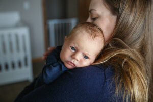 Lifestyle image of Mom with her new baby resting on her shoulder