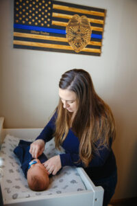 Mom dressing her newborn baby son on a changing table