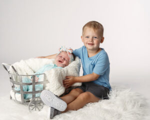 Big brother with his baby sister during a newborn photoshoot