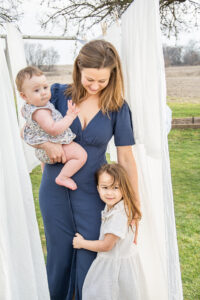 Motherhood Mini Session with young mother and her two daughters outside near a clothesline