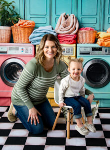 Photo of mother and daughter on a colorful laundromat background during a mom and me photo mini-session 