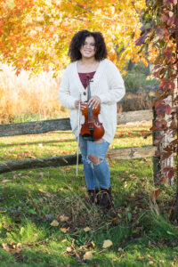 Fall portrait of a teenage girl using her violin as a prop for her senior portraits 