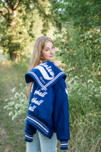 Image of a girl with her letterman's Jacket used as a creative prop for Senior Portraits