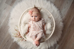 Newborn baby girl laying in a basket