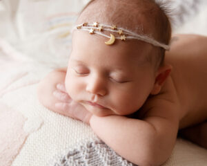 Sleeping newborn baby wearing a pretty headband