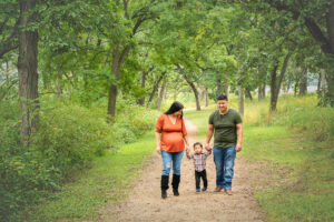 Family of three walking the path at magnolia Bluffs