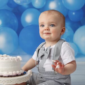 Close up of cute one year old with cake all over his face. 