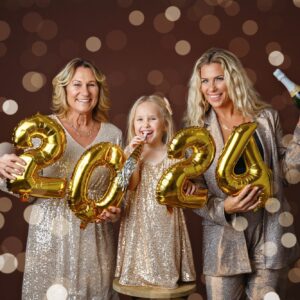 New Years portrait of mom, daughter and granddaughter holding 2024 balloons.