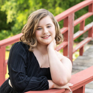 Portrait of a high school senior girl leaning on the koi bridge at Rotary gardens in Janesville