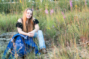 High school senior girl sitting on a rock at Magnolia Bluffs in Evansville.