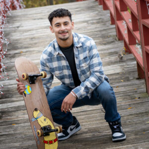 Portrait of senior boy with a skate board on photographed at a favorite senior picture location in Janesville.