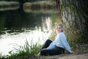 Highschool senior girl sitting near the Sugar river in a location near Janesville