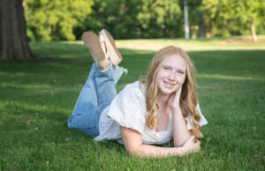 High School Senior Girl laying on the grass at Palmer Park in Janesville