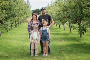 Portrait of a family standing in the orchard at Eugster's farm in Stoughton