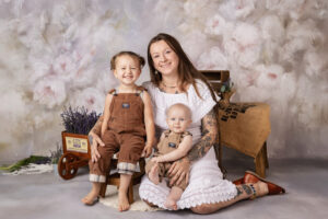 Portrait of a mother with her toddler and baby children.